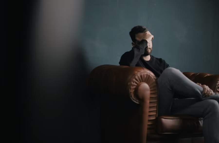 man sitting on couch upset man sitting on couch upset